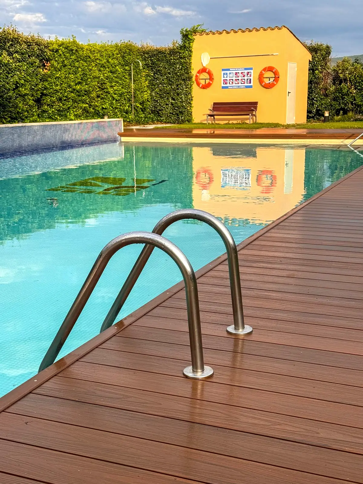 Tarima de composite con escalerilla en la piscina comunitaria de Albons