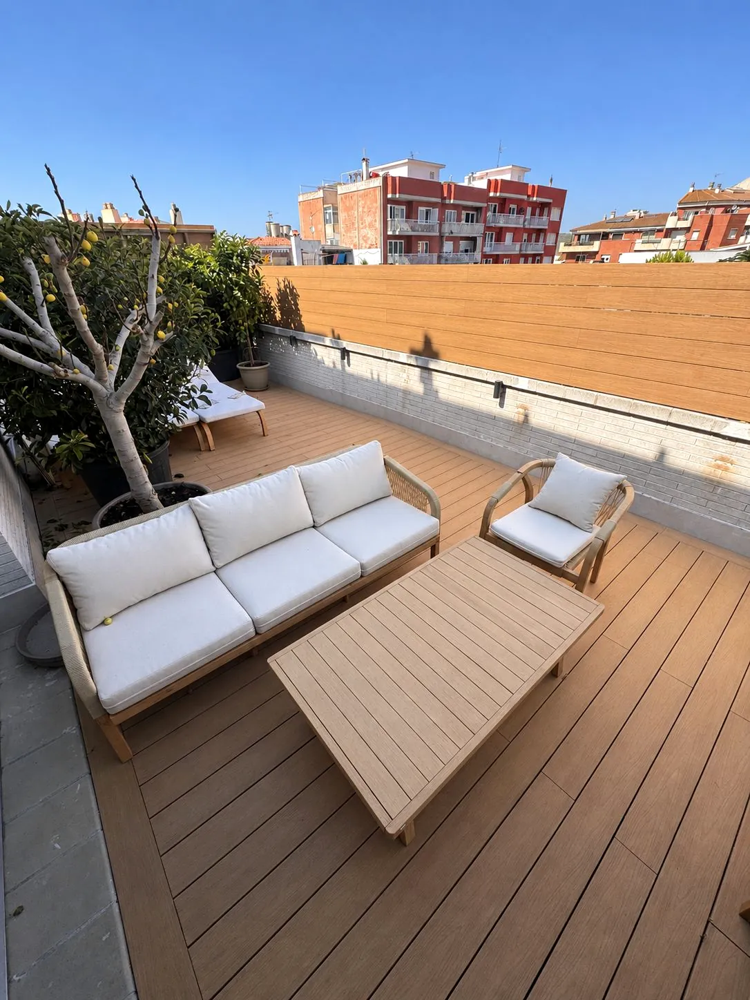 Terraza con tarima de composite y sofás en Blanes