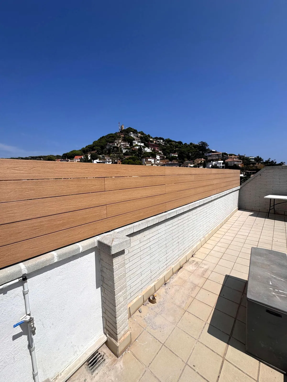 Valla de composite sobre muro con vista a la montaña en Blanes