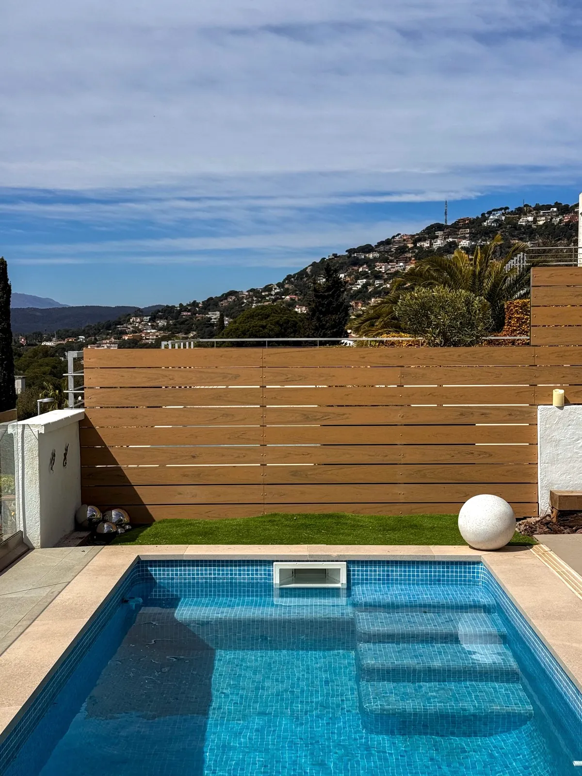 Valla de lamas horizontales de composite junto a una piscina en Lloret