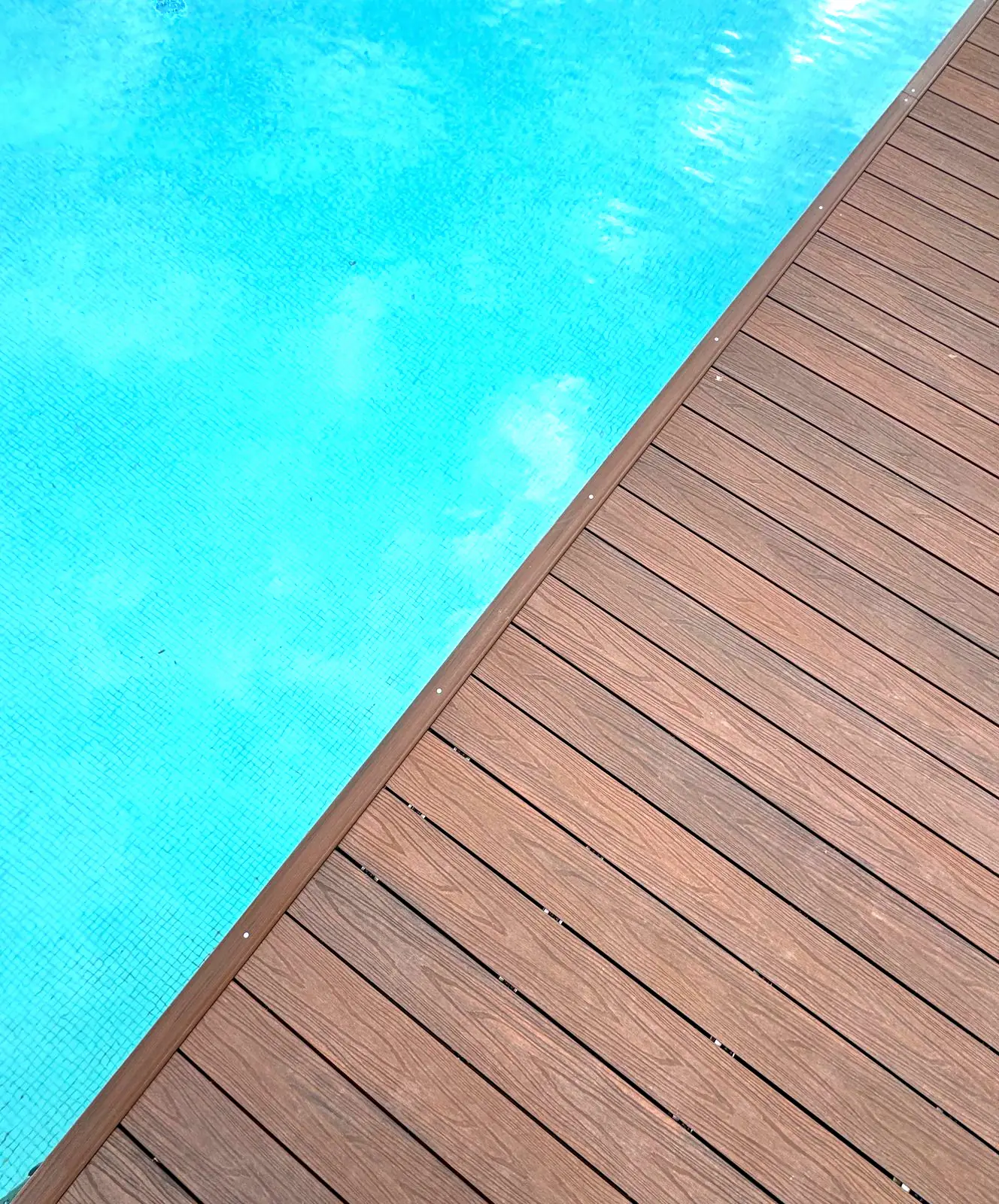 Borde de piscina con tarima de composite en diagonal
